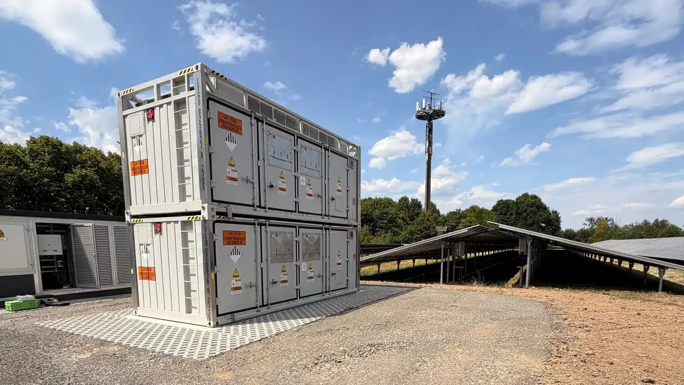 Stand-alone-BESS: gestapelte Batteriespeicher-Container auf erschlossener Fläche neben Solarmodulen